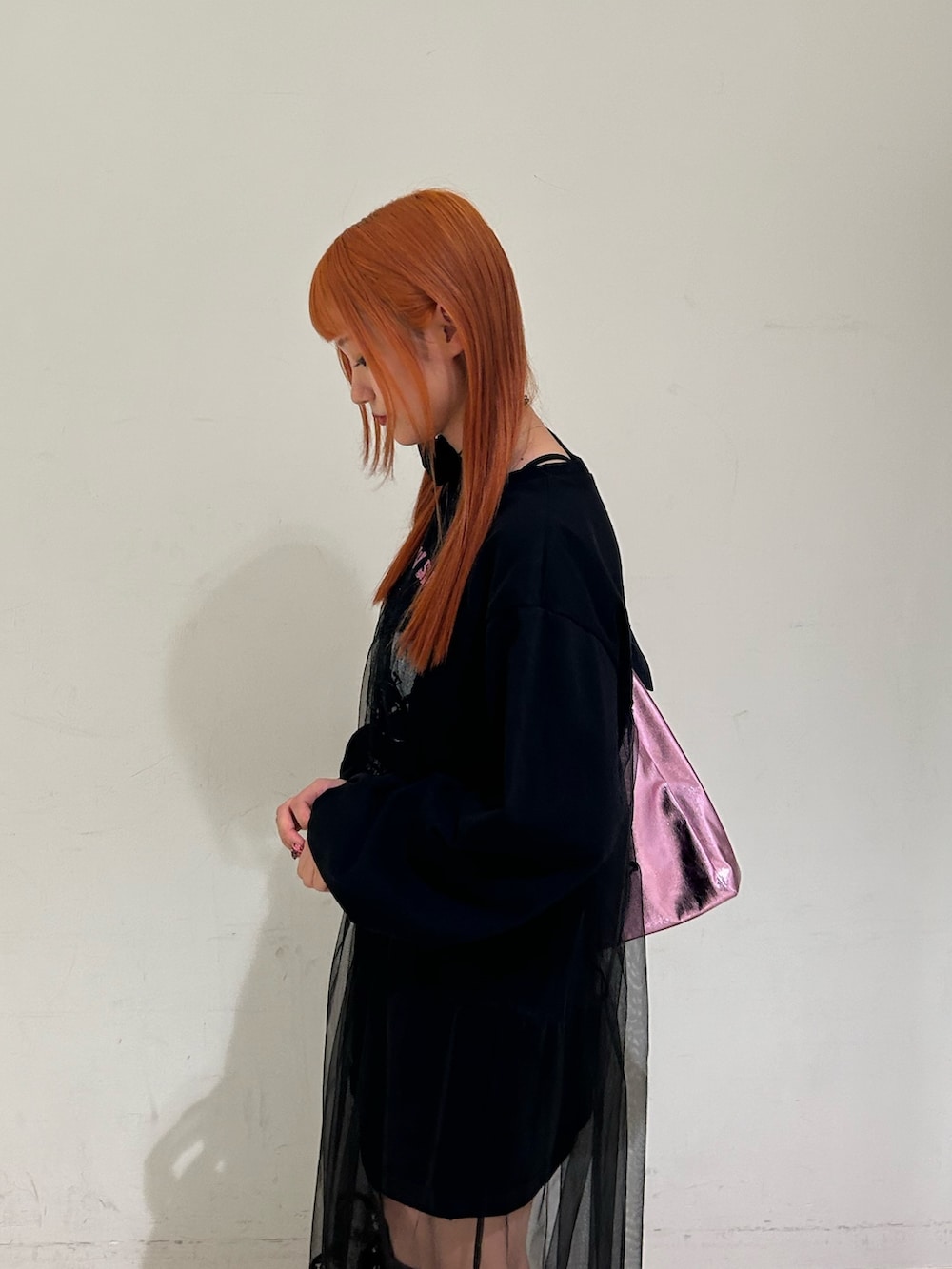 ブラック系のワンピース、ピンク系のトートバッグ、ブラック系のチョーカーを着用したレディースの春コーディネートの5枚目の写真
