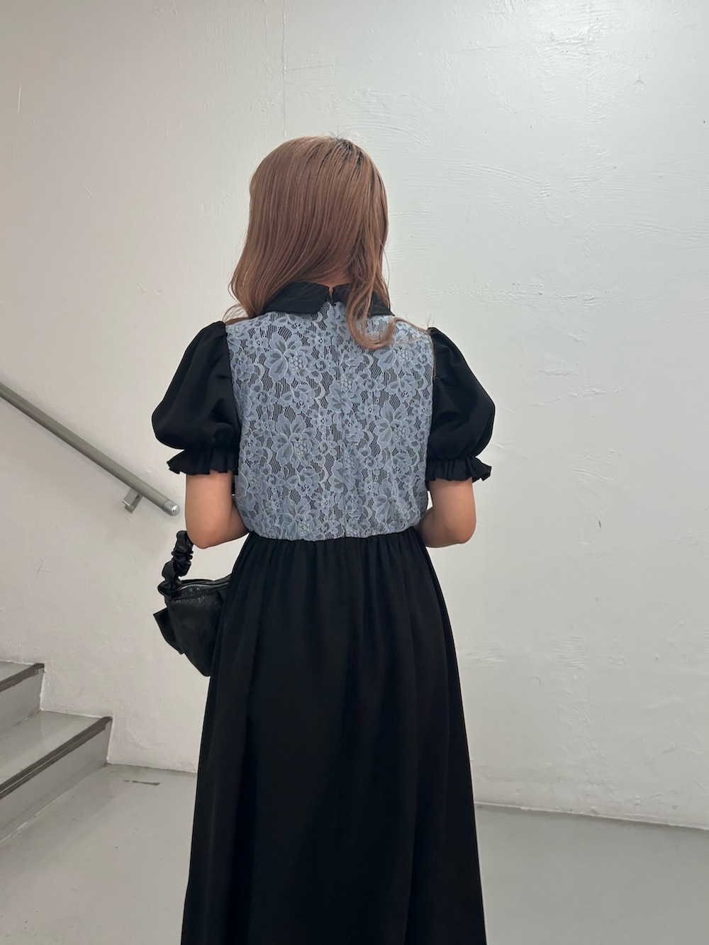 ブラック系のワンピース、ブラック系のハンドバッグ、シルバー系のブレスレットを着用したレディースの春コーディネートの6枚目の写真