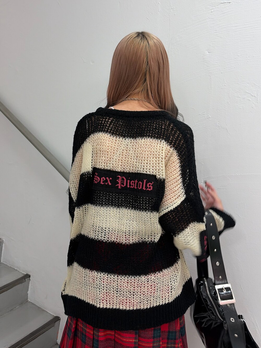 その他のニット/セーター、レッド系のスカート、ブラック系のショルダーバッグを着用したレディースの秋コーディネートの5枚目の写真