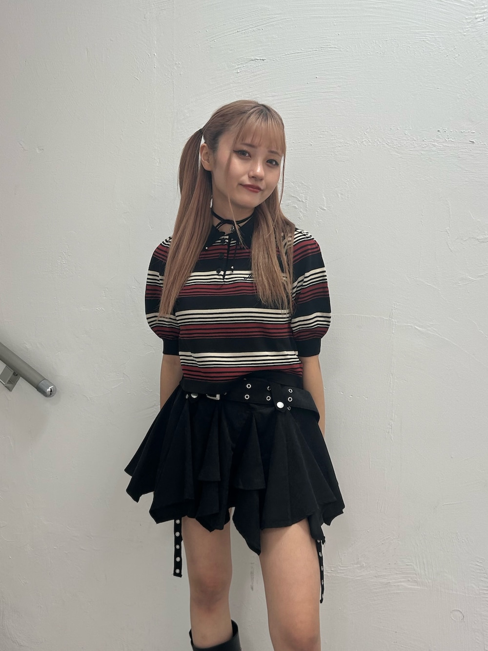 ブラック系のニット/セーター、ブラック系のスカート、ブラック系のブーツを着用したレディースの春コーディネートの4枚目の写真