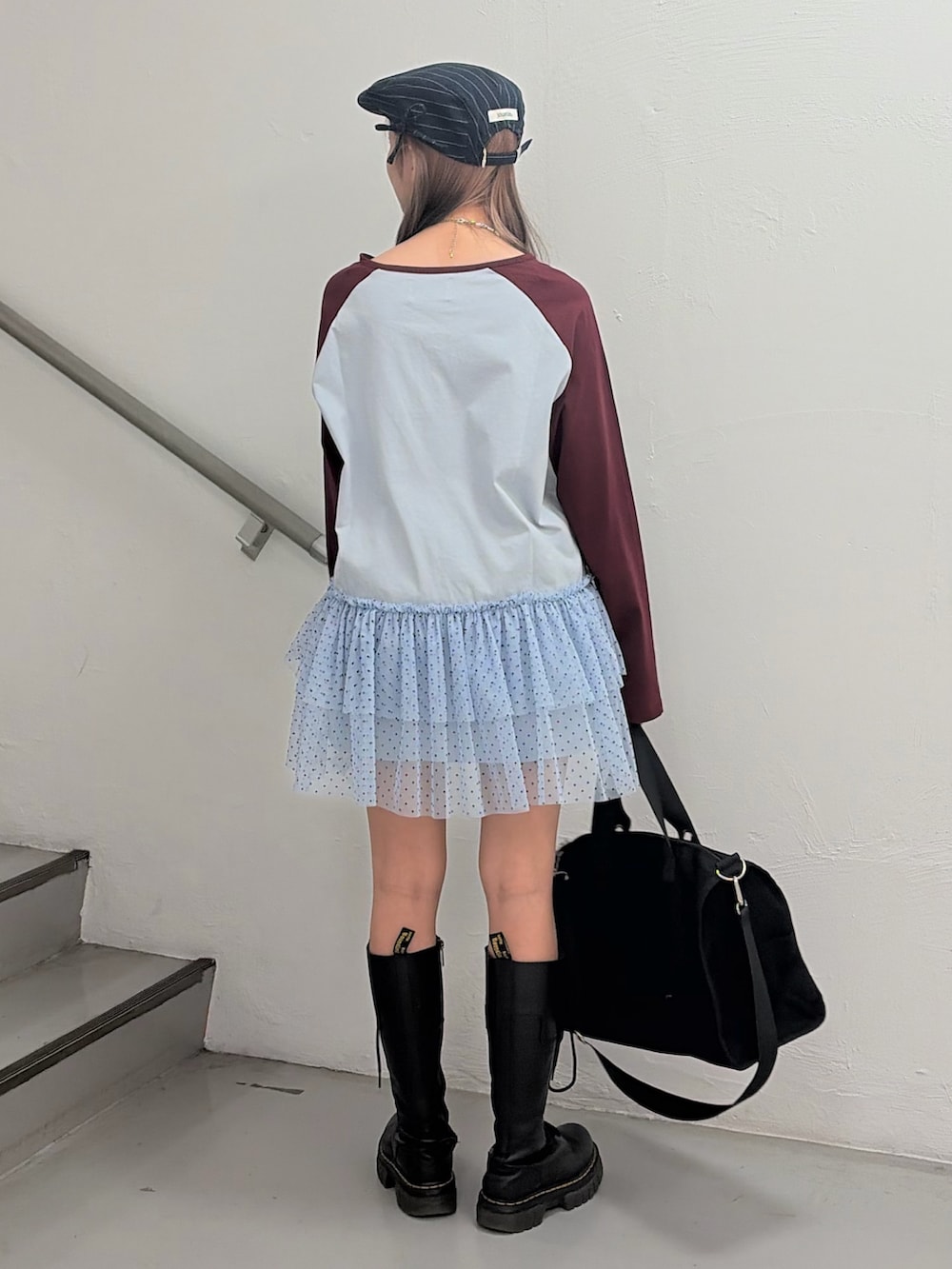 ブルー系のワンピース、ブラック系のボストンバッグ、グレー系のハンチング/ベレー帽を着用したレディースの冬コーディネートの4枚目の写真