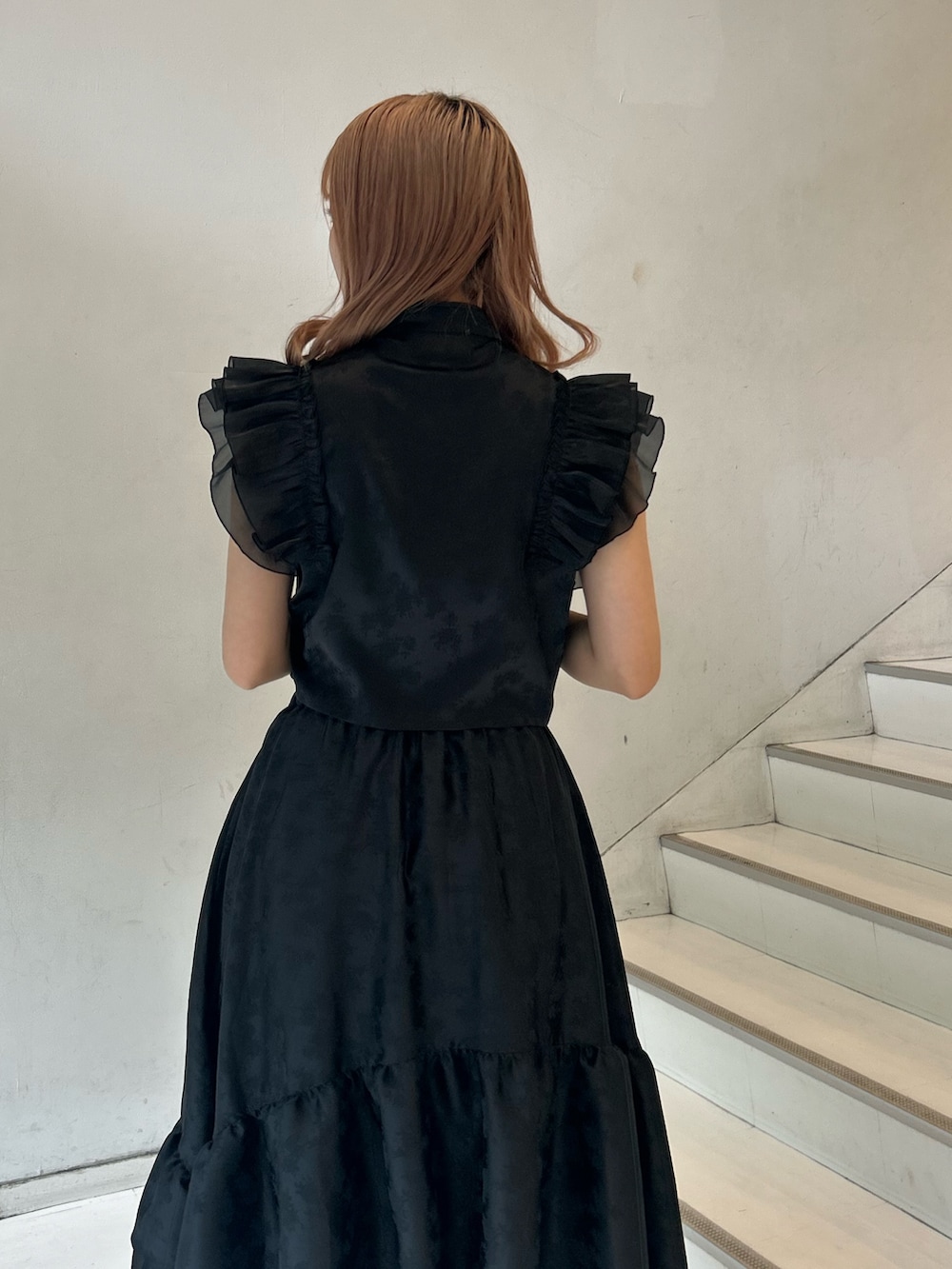 ブラック系のシャツ/ブラウス、ブラック系のスカート、シルバー系のブレスレットを着用したレディースの春コーディネートの6枚目の写真