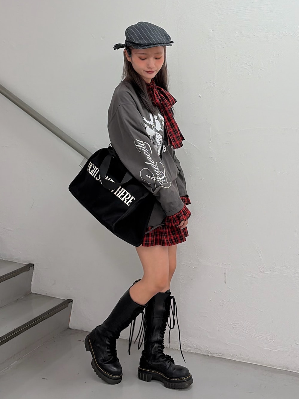 ブラック系のTシャツ/カットソー、レッド系のワンピース、ブラック系のボストンバッグを着用したレディースの冬コーディネートの2枚目の写真