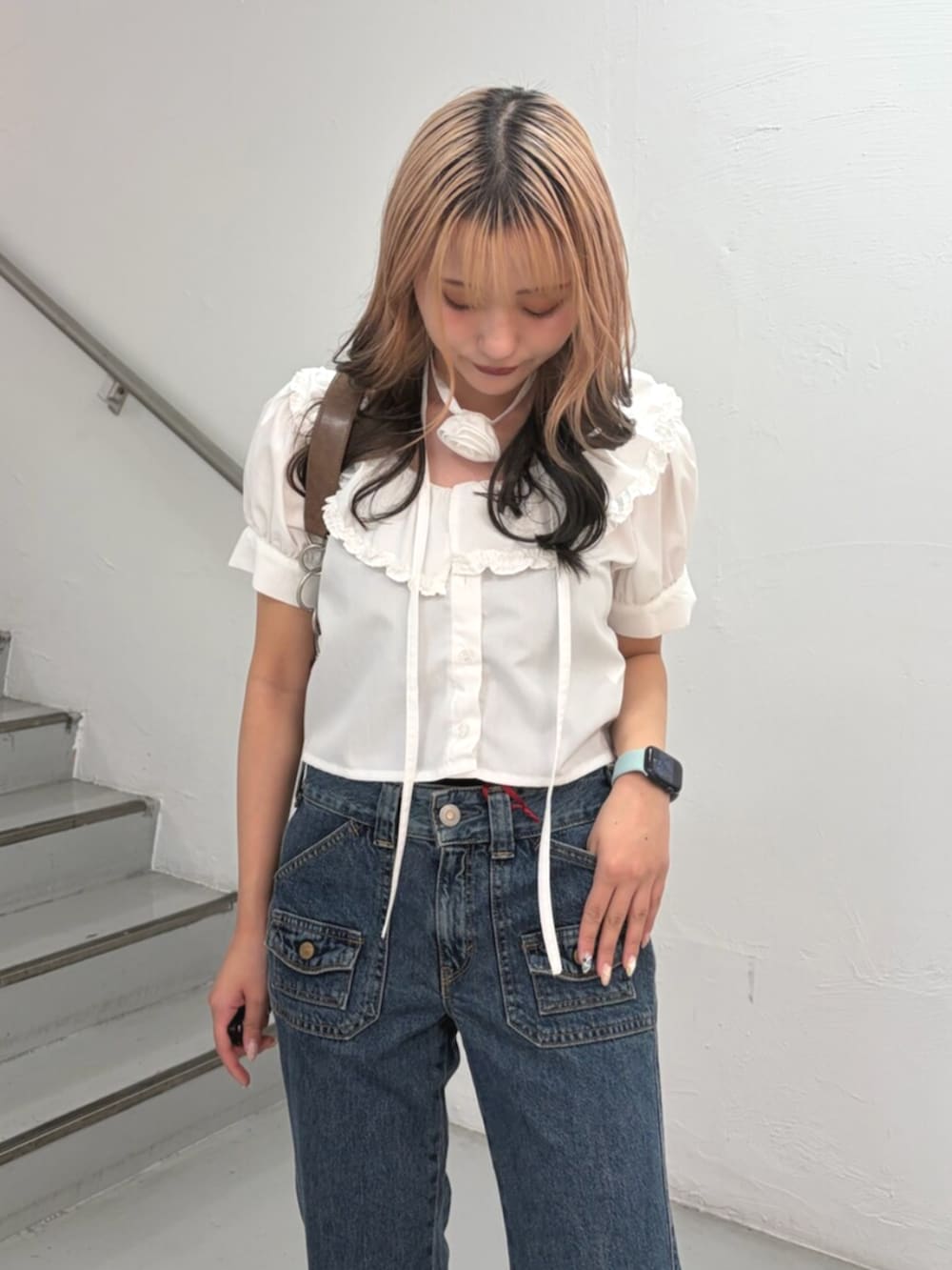 ホワイト系のシャツ/ブラウス、ブルー系のデニムパンツ、ブラウン系のハンドバッグを着用したレディースの春コーディネートの5枚目の写真