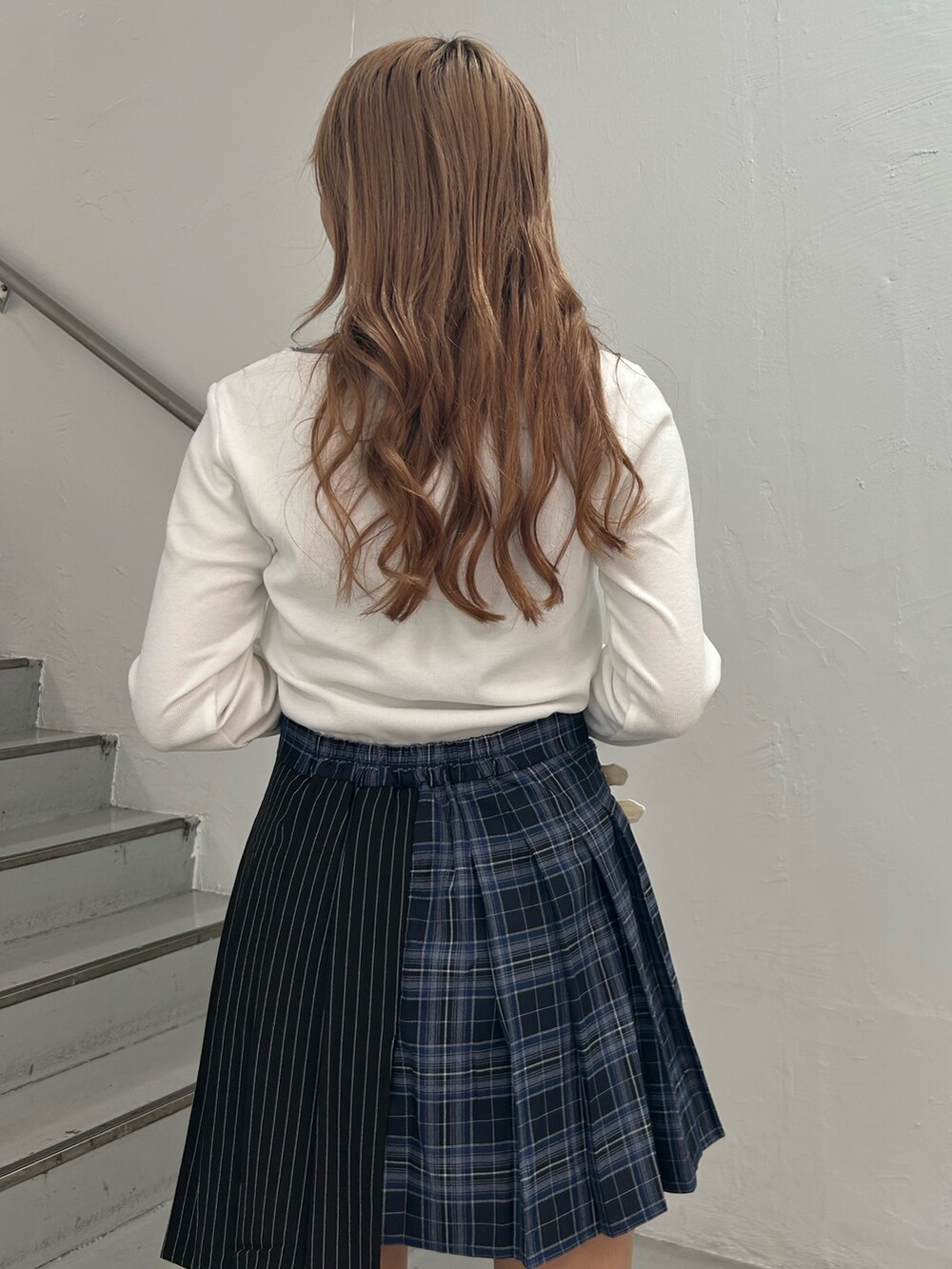 ホワイト系のTシャツ/カットソー、ブルー系のスカート、ブラウン系のブーツを着用したレディースの秋コーディネートの6枚目の写真