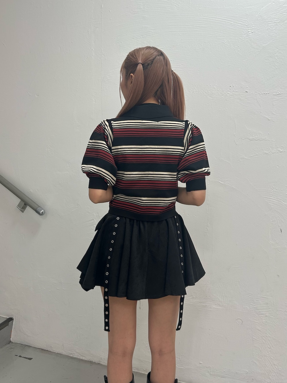 ブラック系のニット/セーター、ブラック系のスカート、ブラック系のブーツを着用したレディースの春コーディネートの6枚目の写真