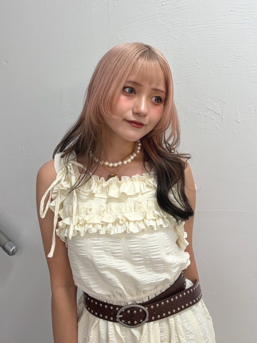 ブラウン系のハンドバッグ、ホワイト系のワンピース、ブラウン系のベルトを着用したレディースの夏コーディネートの4枚目の写真