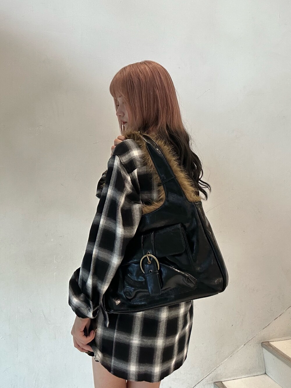 ブラック系のシャツ/ブラウス、ブラック系のスカート、ブラック系のハンドバッグを着用したレディースの秋コーディネートの6枚目の写真