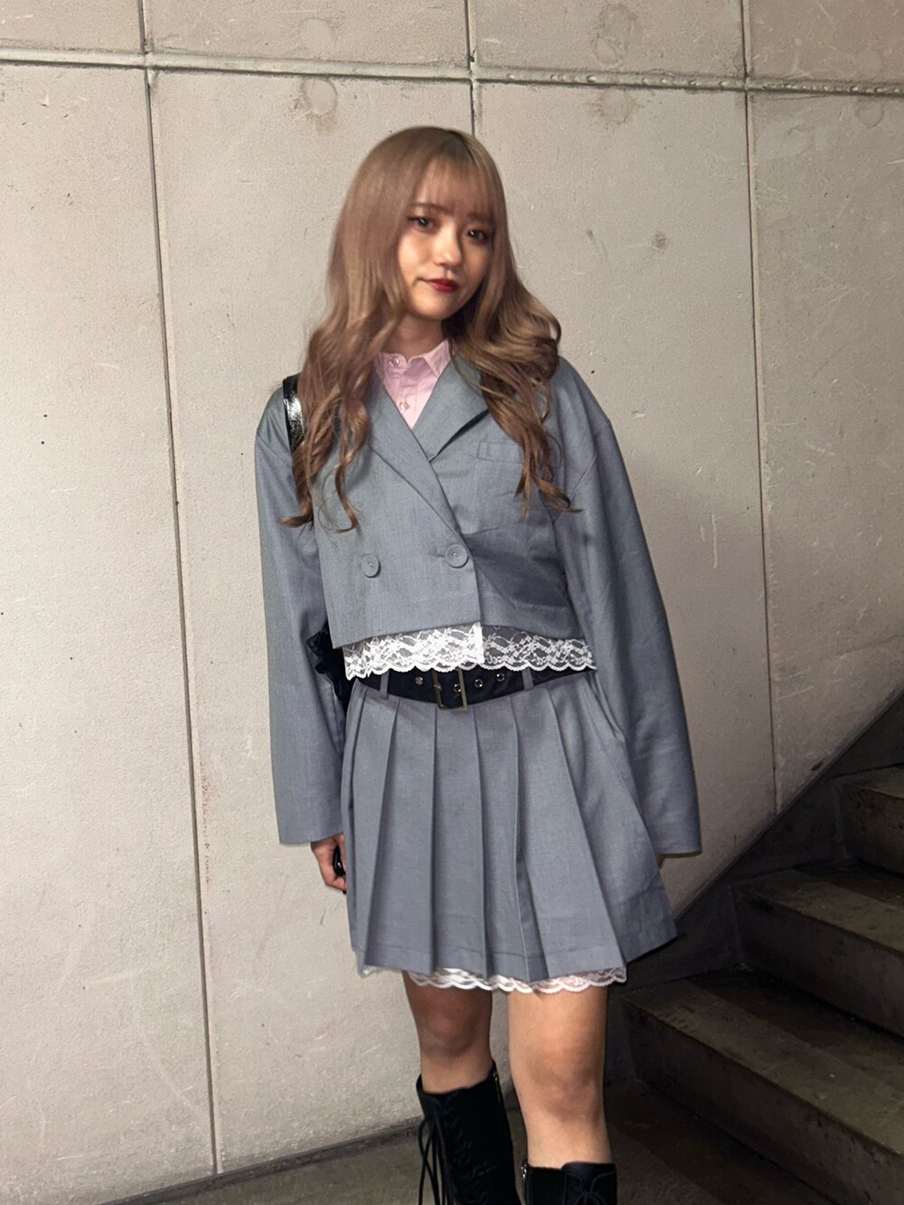 ブラック系のトートバッグ、グレー系のテーラードジャケット、グレー系のスカートを着用したレディースの冬コーディネートの5枚目の写真