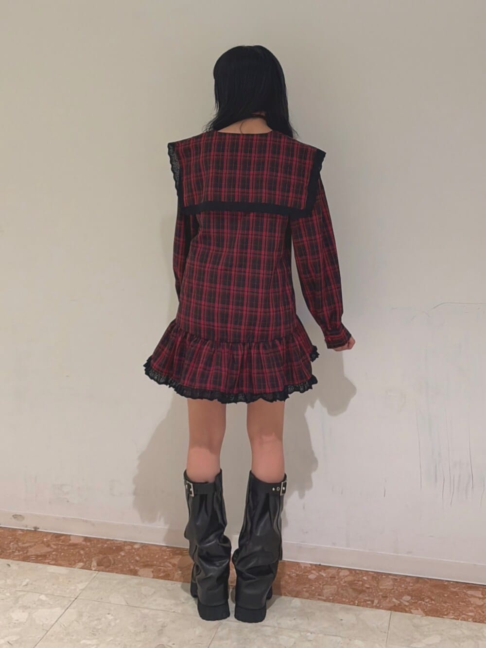 レッド系のワンピース、ブラック系のブーツを着用したレディースの夏コーディネートの3枚目の写真