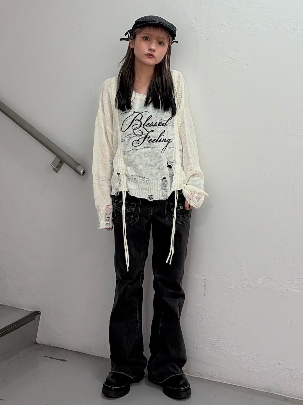 ホワイト系のニット/セーター、ブラック系のデニムパンツ、グレー系のハンチング/ベレー帽を着用したレディースの冬コーディネートの2枚目の写真