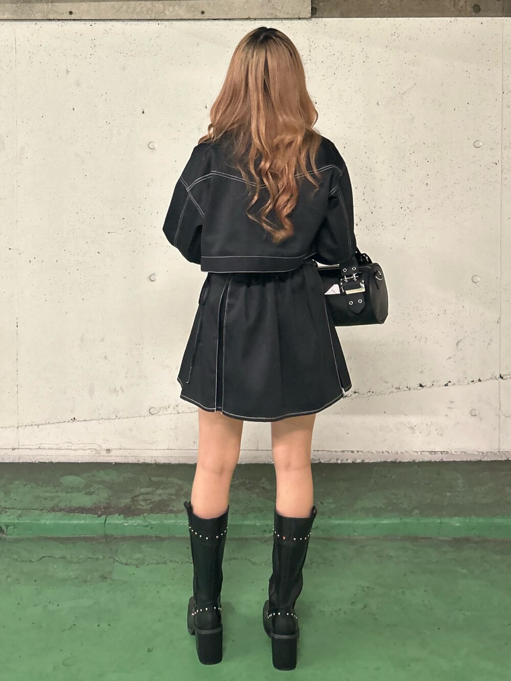 ブラック系のワンピース、レッド系のTシャツ/カットソー、ブラック系のボストンバッグを着用したレディースの春コーディネートの3枚目の写真