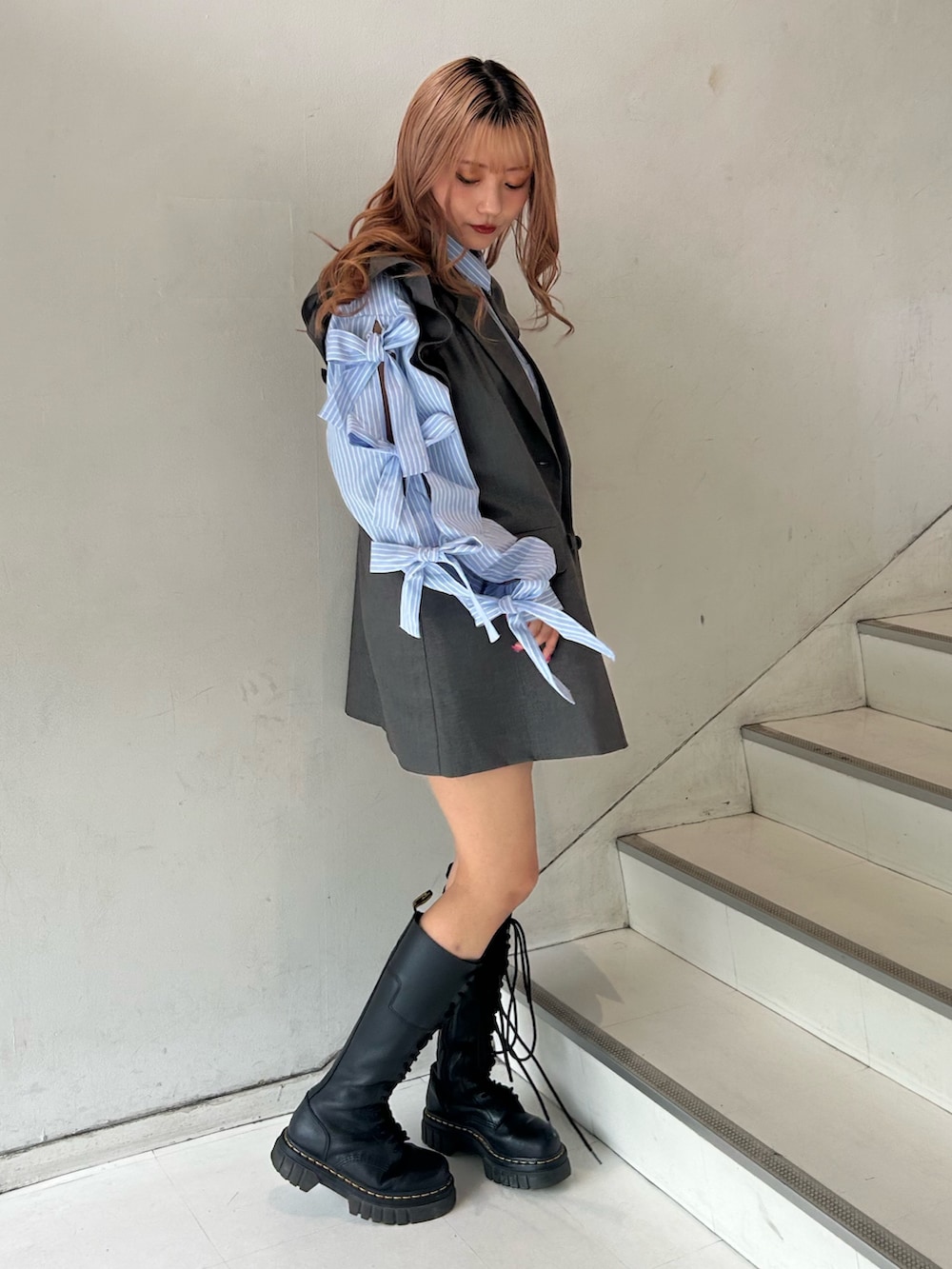 グレー系のワンピース、ブルー系のシャツ/ブラウス、シルバー系のネックレスを着用したレディースの春コーディネートの2枚目の写真