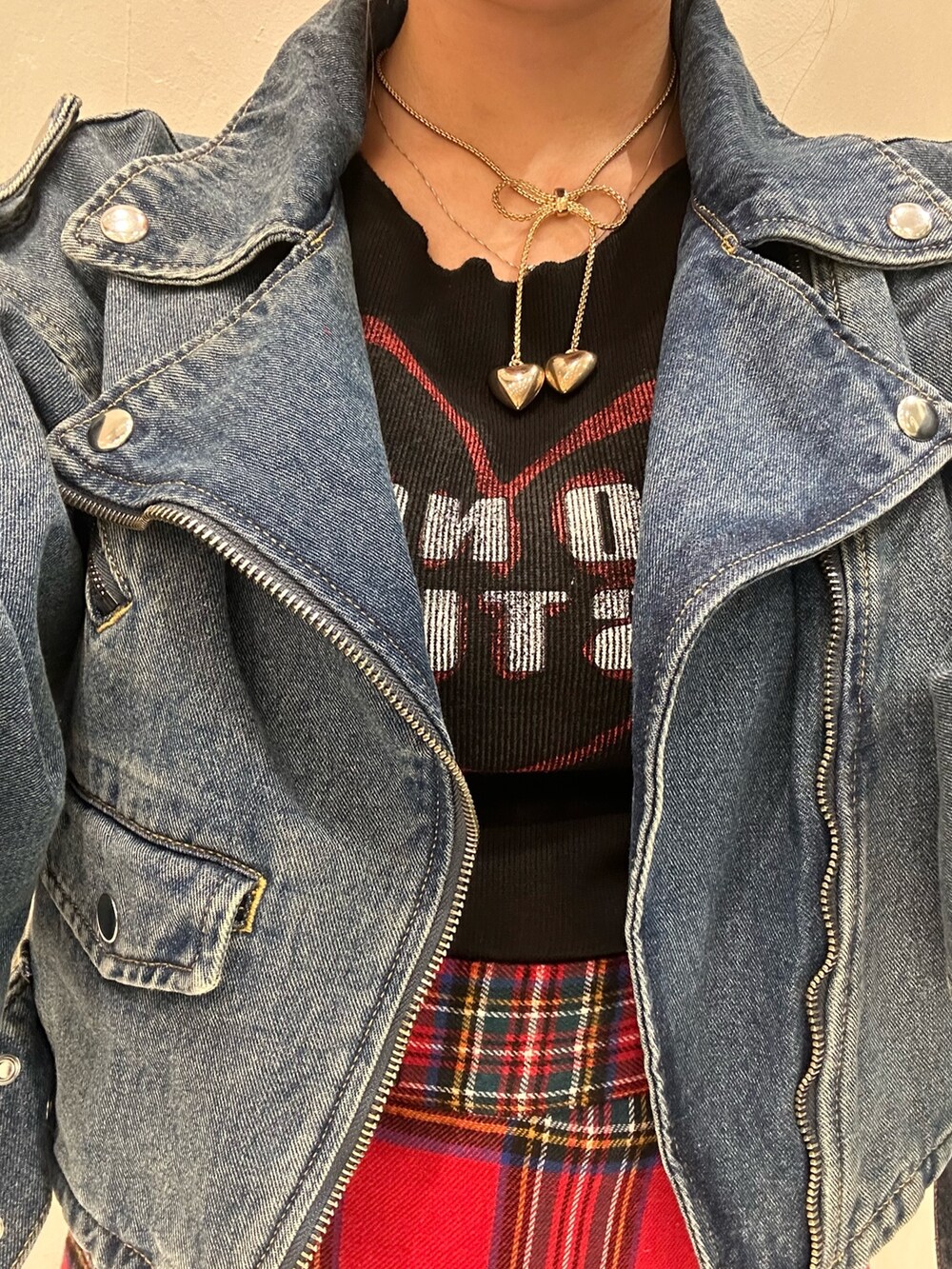 レッド系のスカート、ブラック系のTシャツ/カットソー、ブルー系のライダースジャケットを着用したレディースの秋コーディネートの7枚目の写真