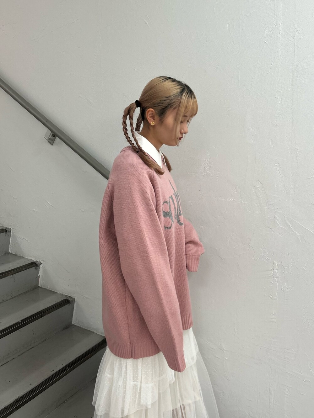 ピンク系のニット/セーター、ホワイト系のシャツ/ブラウス、ホワイト系のスカートを着用したレディースの冬コーディネートの5枚目の写真