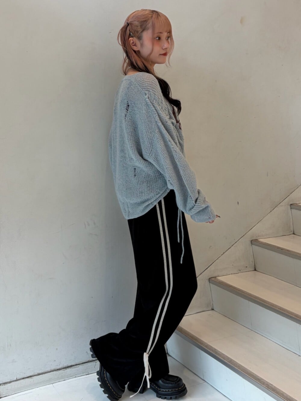 ブルー系のニット/セーター、ブラック系のその他パンツ、シルバー系のネックレスを着用したレディースの秋コーディネートの4枚目の写真