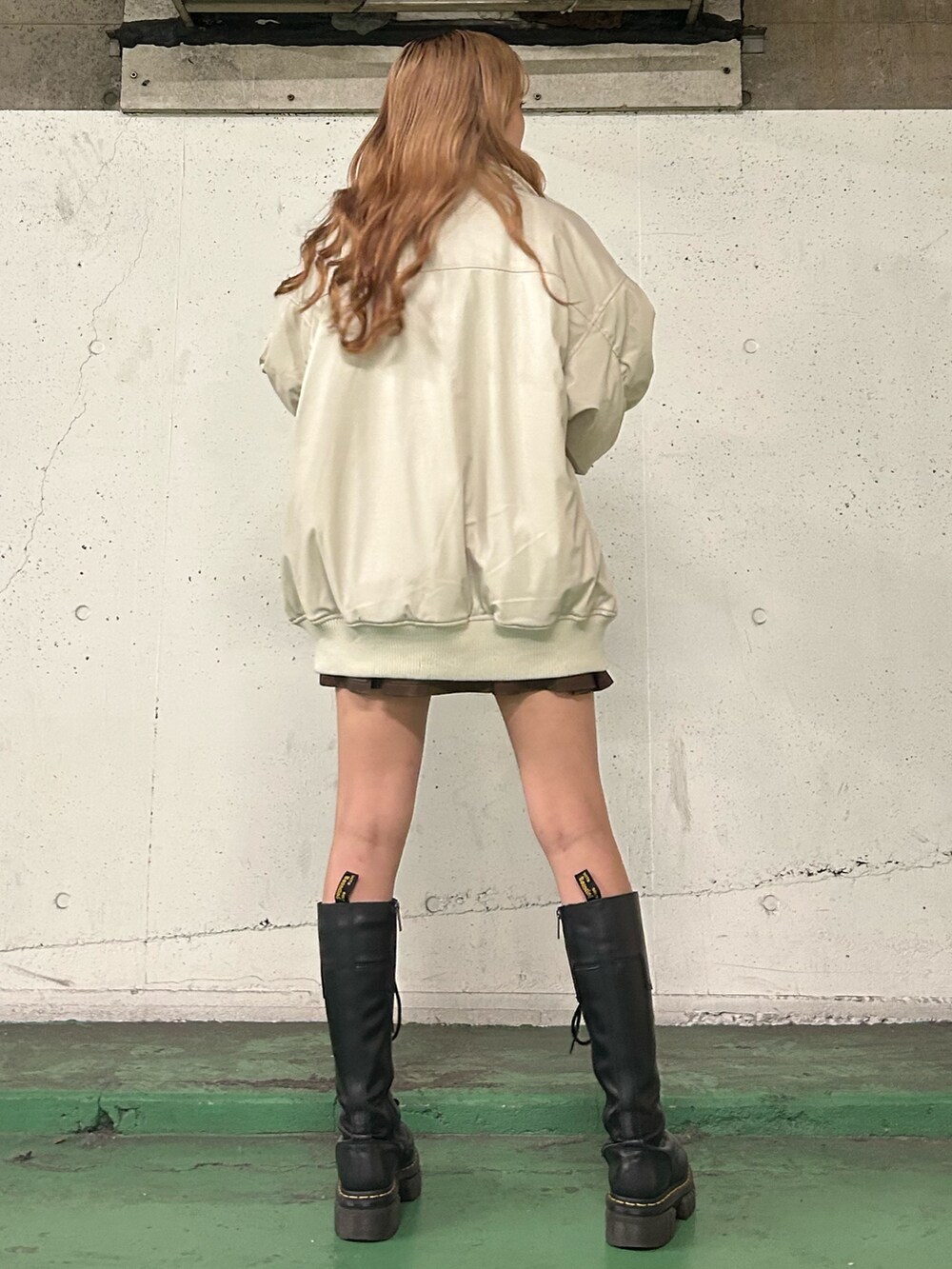 ホワイト系のブルゾン、レッド系のTシャツ/カットソー、ブラウン系のスカートを着用したレディースの秋コーディネートの3枚目の写真