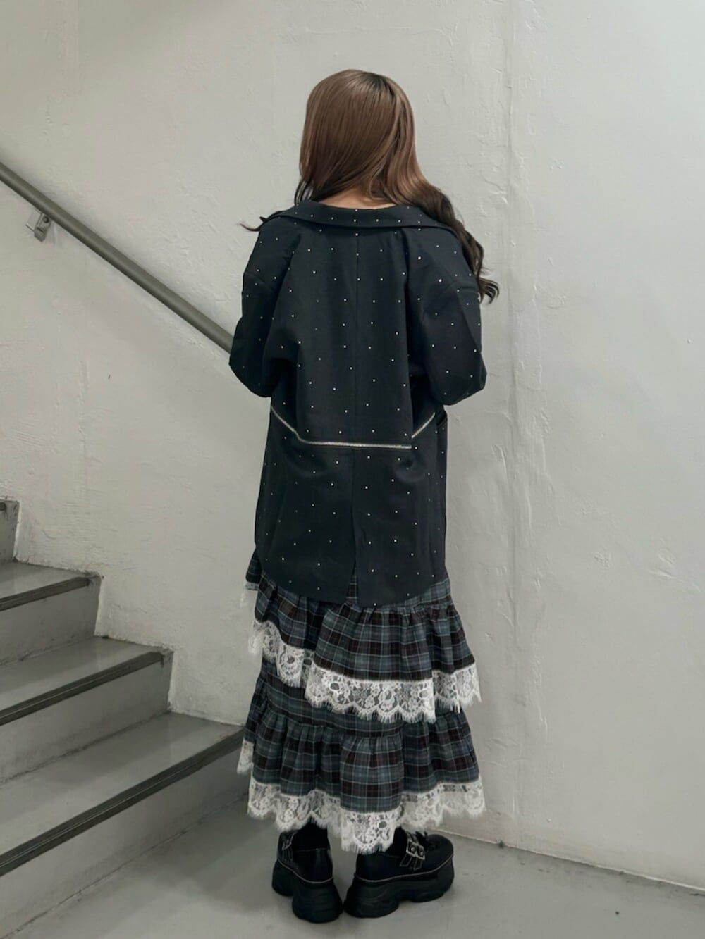 グレー系のテーラードジャケット、ブラック系のスニーカー、ブラウン系のワンピースを着用したレディースの秋コーディネートの3枚目の写真