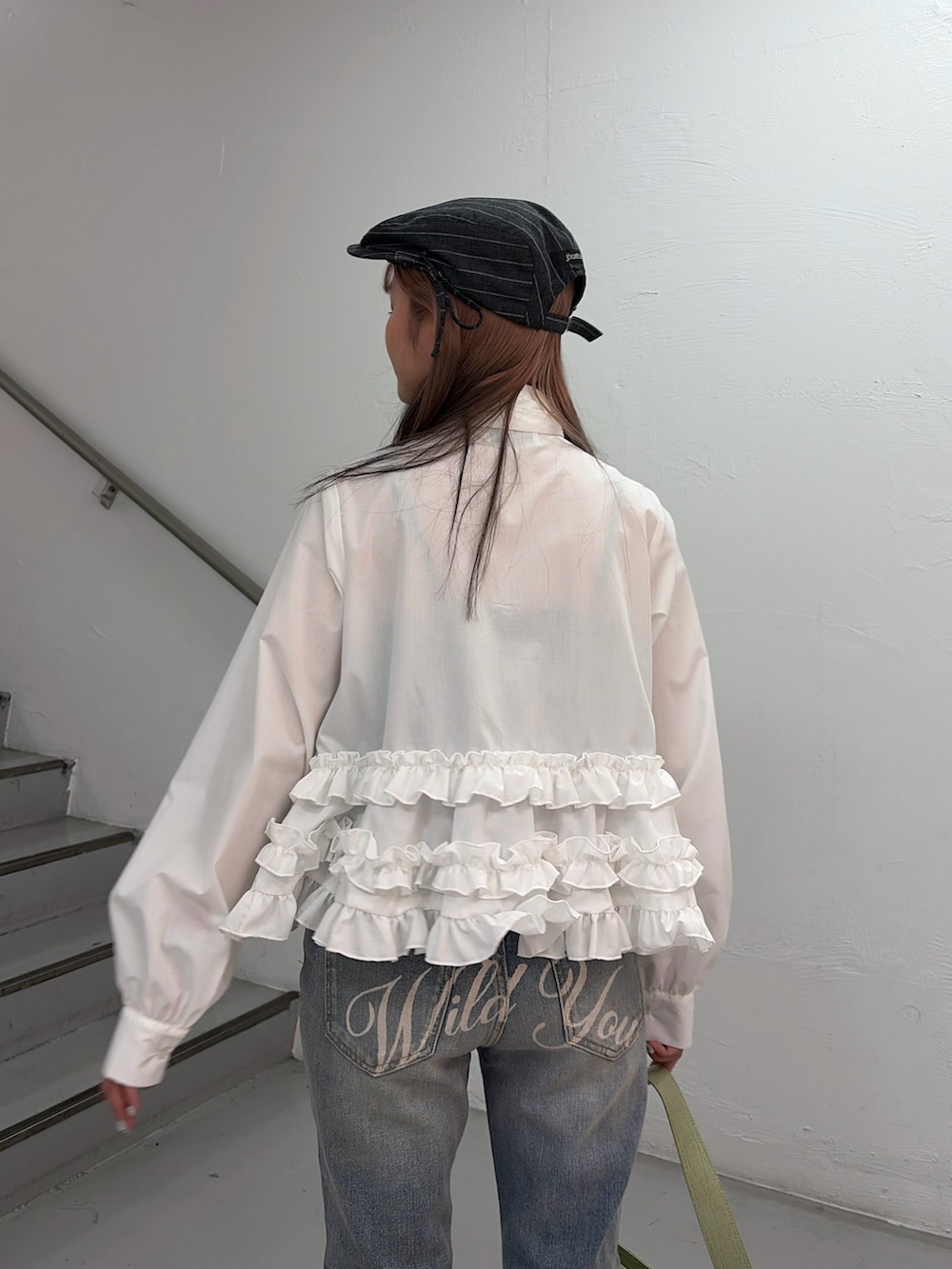 ホワイト系のシャツ/ブラウス、ブルー系のデニムパンツ、グリーン系のハンドバッグを着用したレディースの冬コーディネートの6枚目の写真