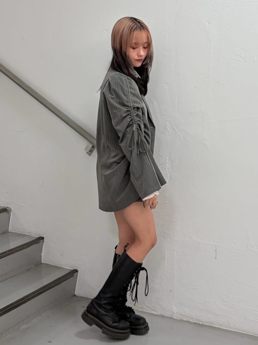 グレー系のテーラードジャケット、グレー系のスカート、ホワイト系のシャツ/ブラウスを着用したレディースの冬コーディネートの4枚目の写真