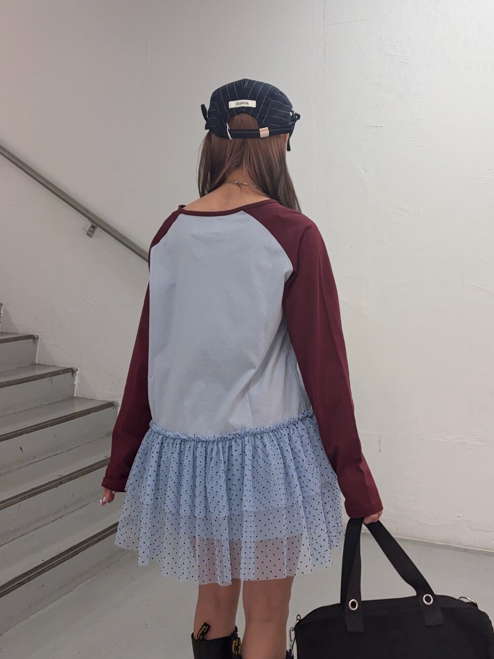 ブルー系のワンピース、ブラック系のボストンバッグ、グレー系のハンチング/ベレー帽を着用したレディースの冬コーディネートの7枚目の写真