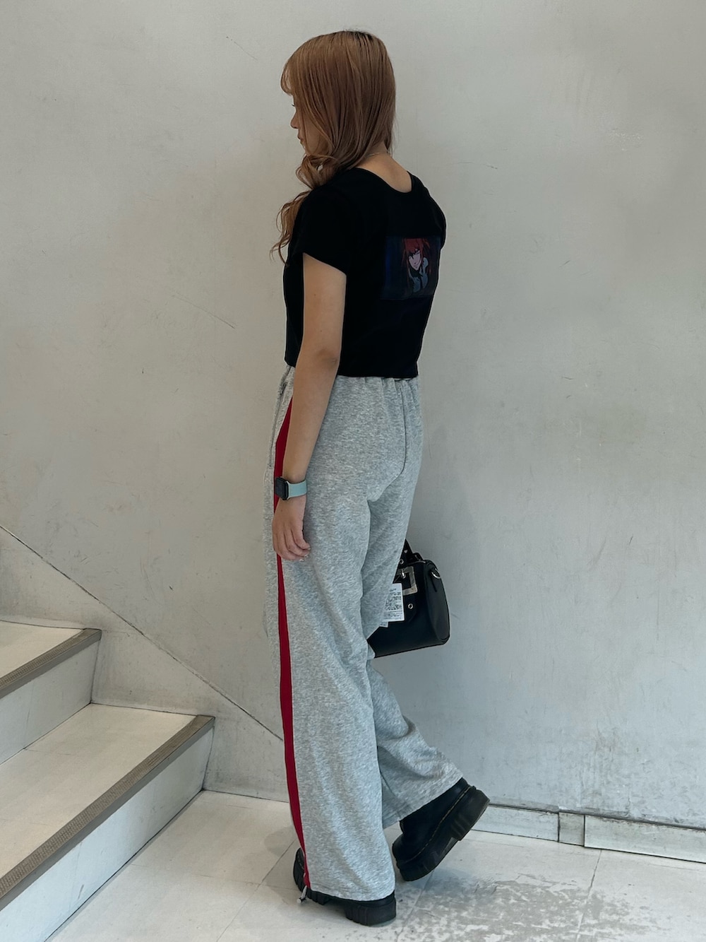 ブラック系のTシャツ/カットソー、グレー系のスウェットパンツ、ブラック系のボストンバッグを着用したレディースの春コーディネートの2枚目の写真