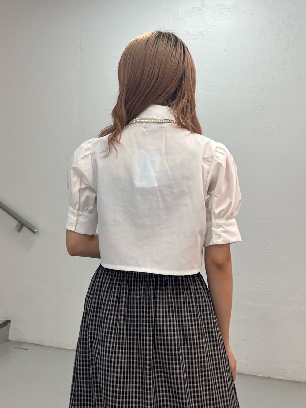 ホワイト系のシャツ/ブラウス、ブラック系のスカート、ホワイト系のネックレスを着用したレディースの夏コーディネートの6枚目の写真