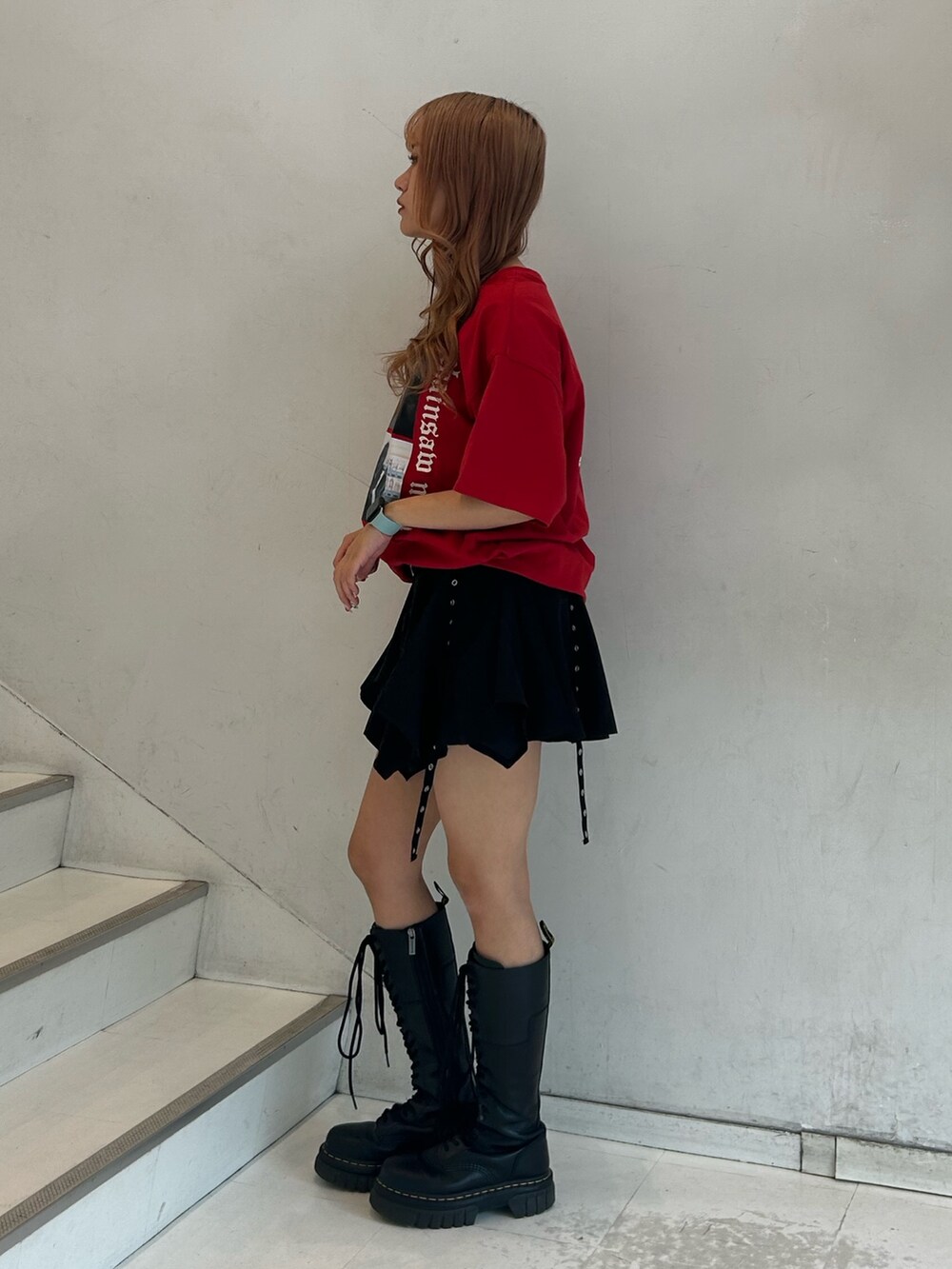 レッド系のTシャツ/カットソー、ブラック系のスカート、ブラック系のチョーカーを着用したレディースの春コーディネートの2枚目の写真