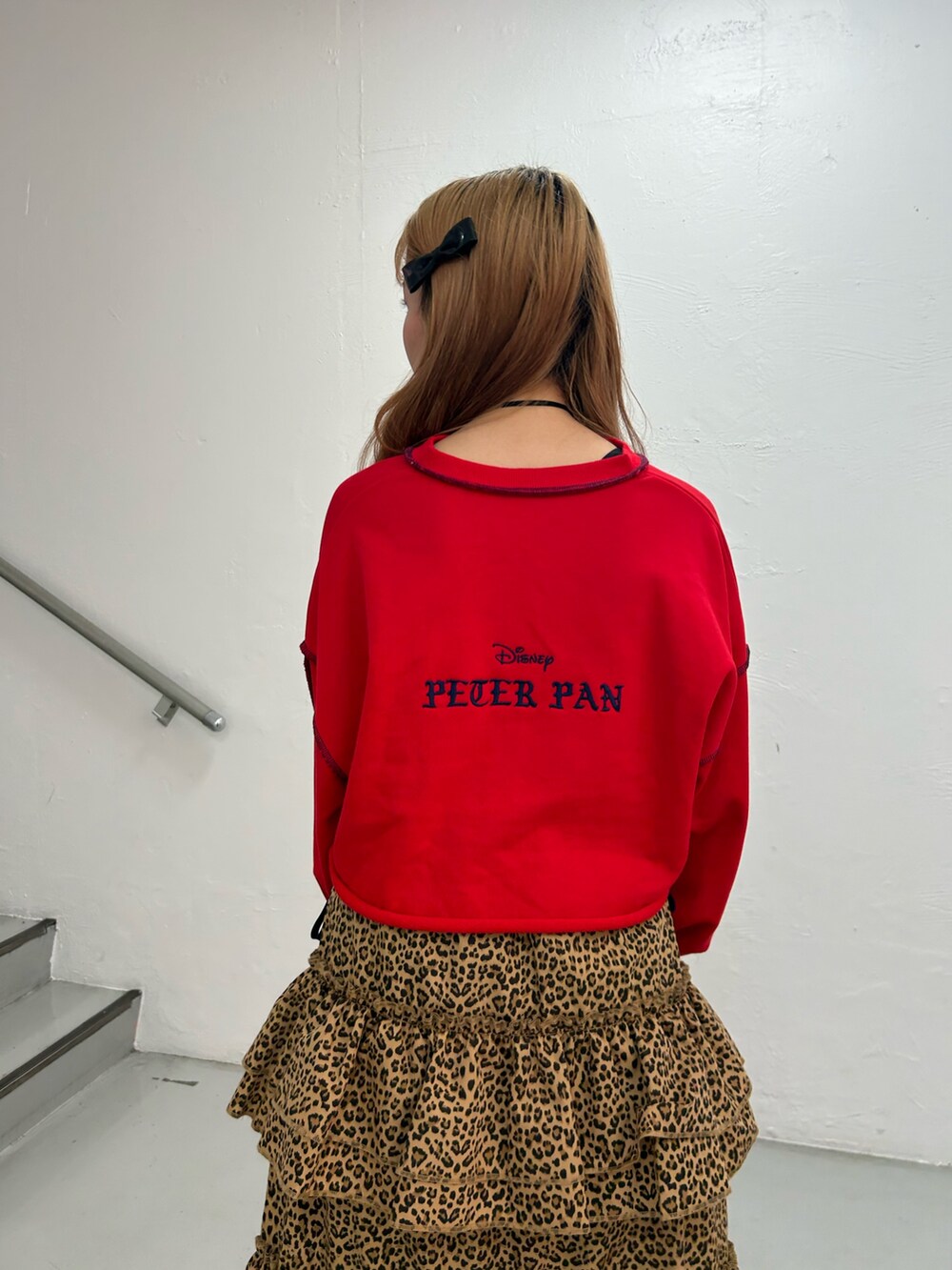 レッド系のスウェット、ブラウン系のスカート、ブラック系のバレエシューズを着用したレディースの夏コーディネートの6枚目の写真