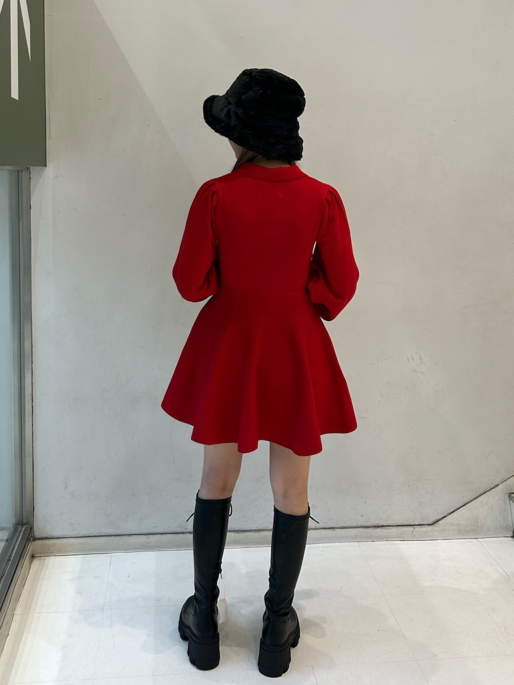 レッド系のワンピース、ブラック系のブーツを着用したレディースの秋コーディネートの4枚目の写真
