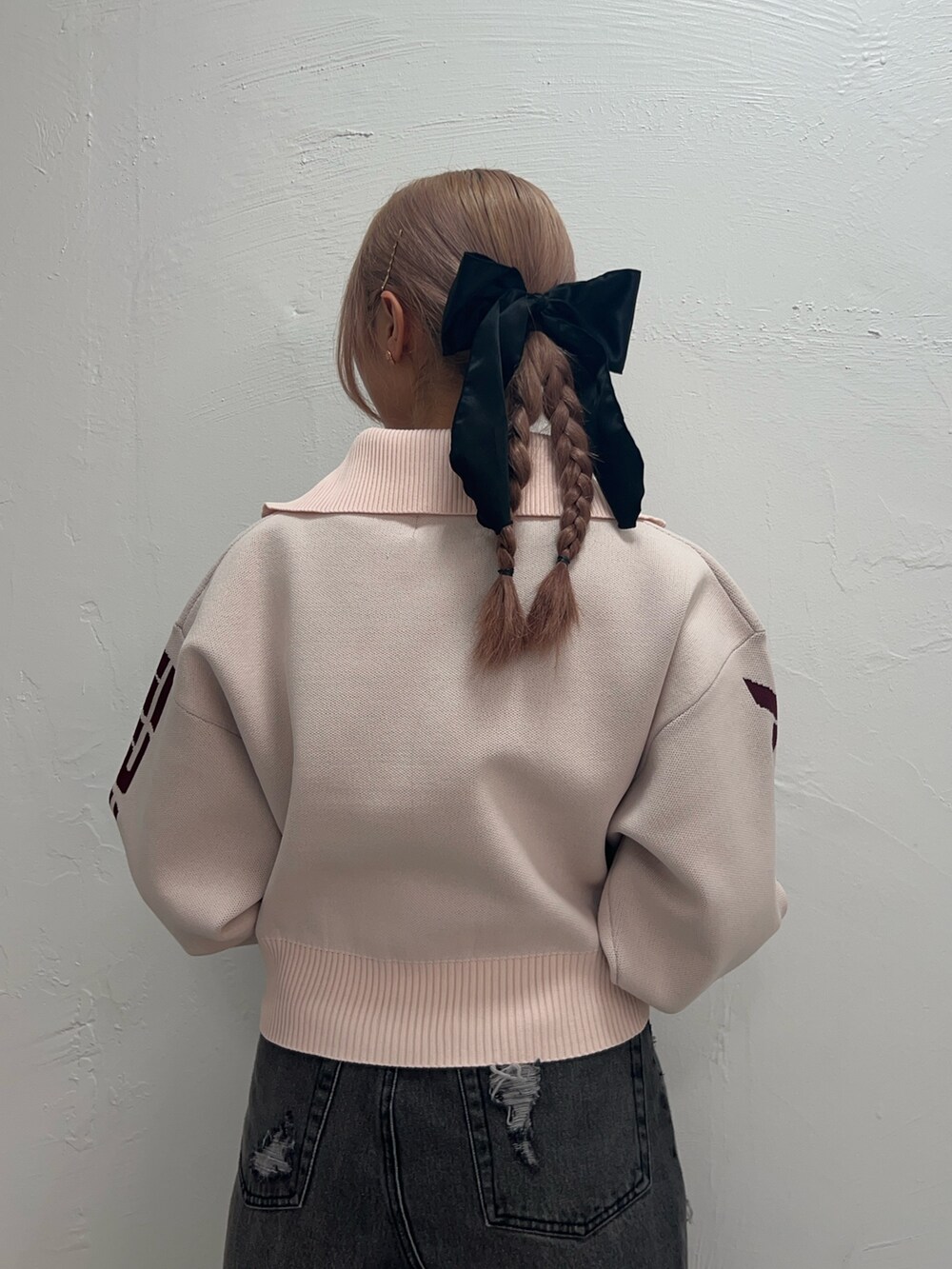 ピンク系のニット/セーター、ブラック系のデニムスカート、ピンク系のネックレスを着用したレディースの冬コーディネートの6枚目の写真