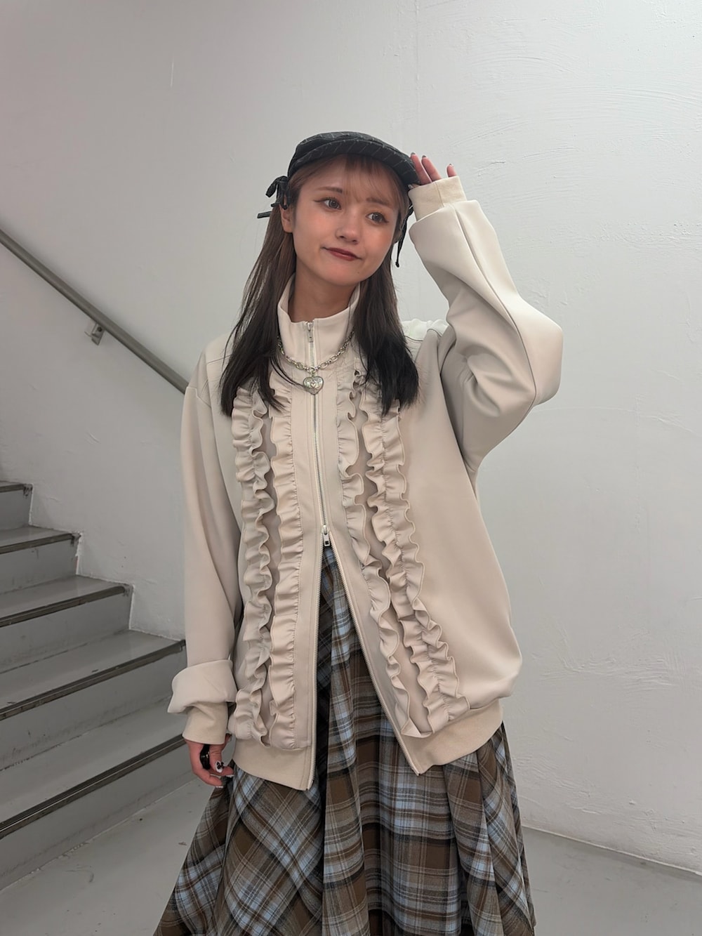 ホワイト系のジャージ、ブラウン系のスカート、グレー系のハンチング/ベレー帽を着用したレディースの冬コーディネートの5枚目の写真