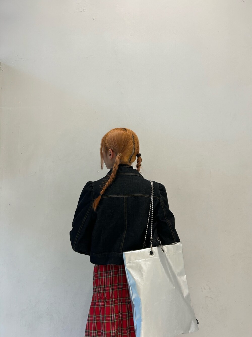 ブラック系のニット/セーター、ブラック系のワンピース、レッド系のスカートを着用したレディースの春コーディネートの6枚目の写真