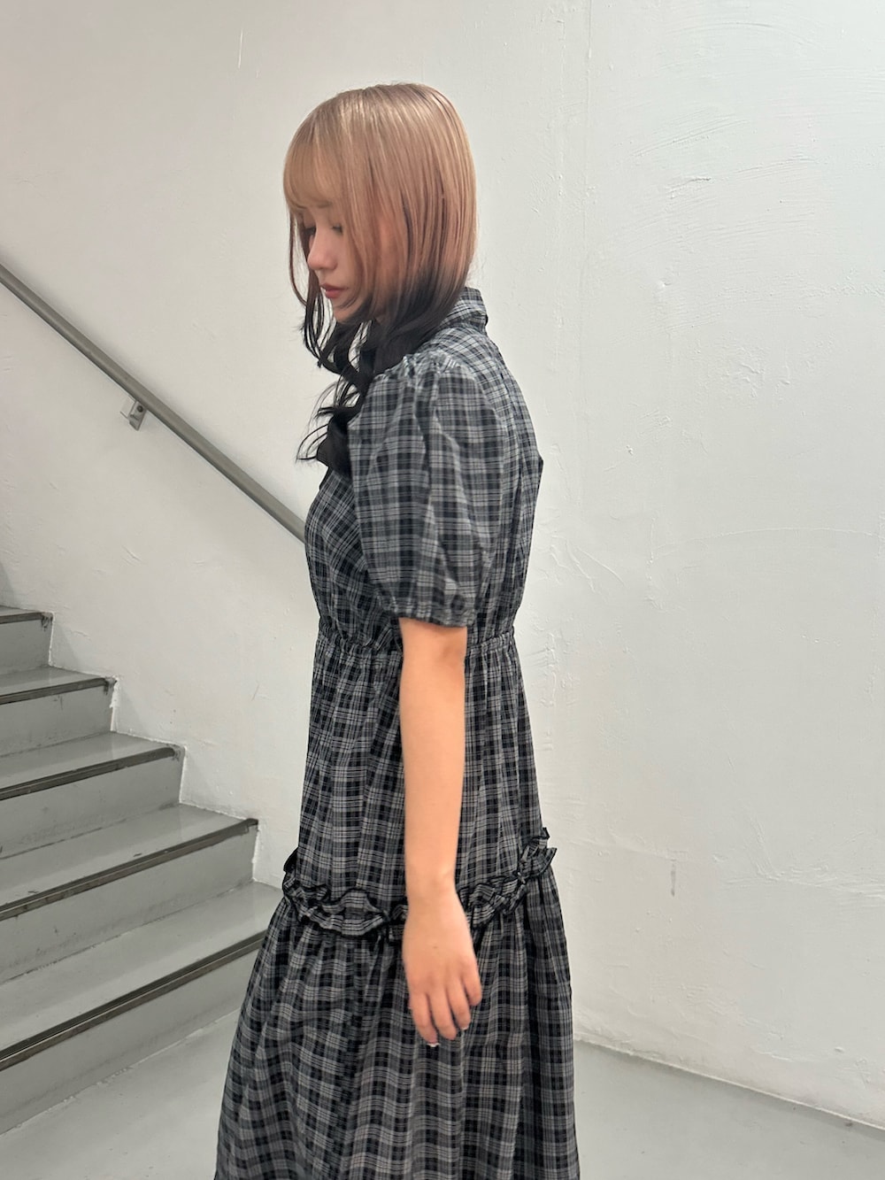 ブラック系のワンピース、ゴールド系のブレスレットを着用したレディースの夏コーディネートの5枚目の写真