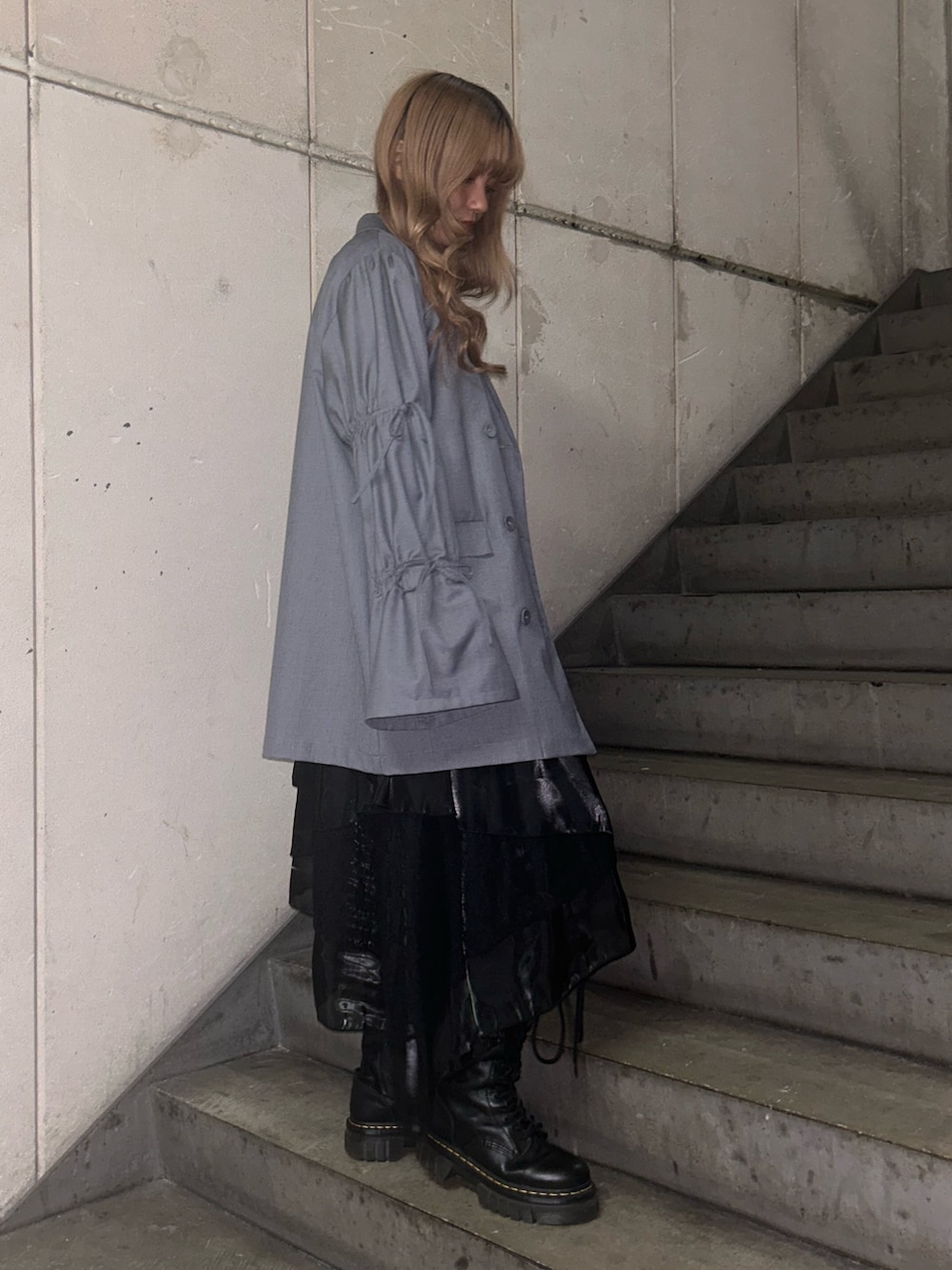 グレー系のテーラードジャケット、ブラック系のTシャツ/カットソー、ブラック系のスカートを着用したレディースの冬コーディネートの2枚目の写真