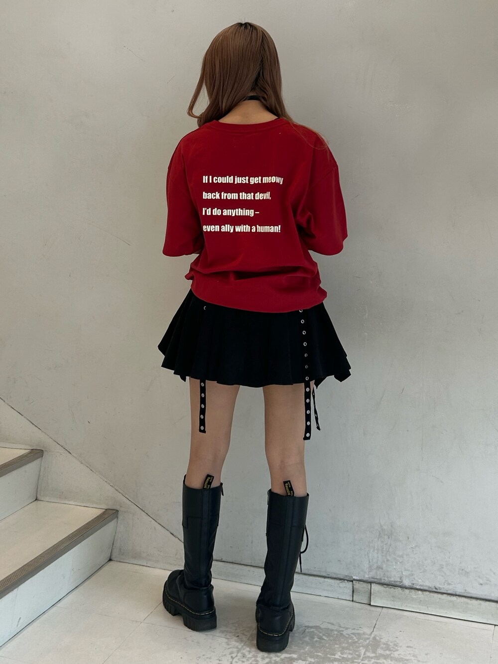レッド系のTシャツ/カットソー、ブラック系のスカート、ブラック系のチョーカーを着用したレディースの春コーディネートの3枚目の写真