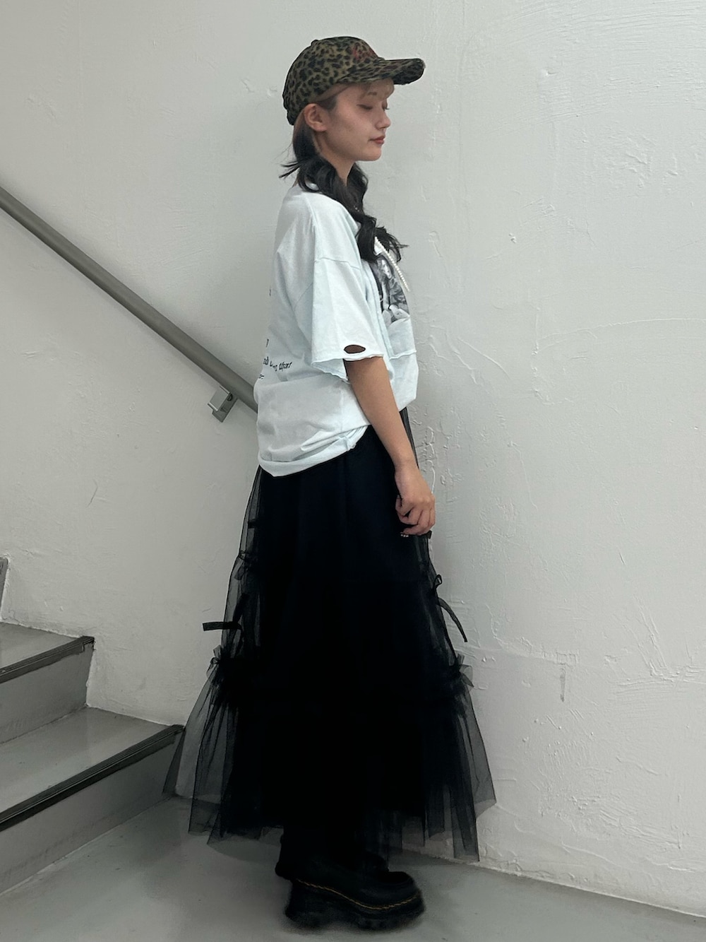 ブルー系のTシャツ/カットソー、ブラック系のスカート、ブラウン系のキャップを着用したレディースの夏コーディネートの3枚目の写真