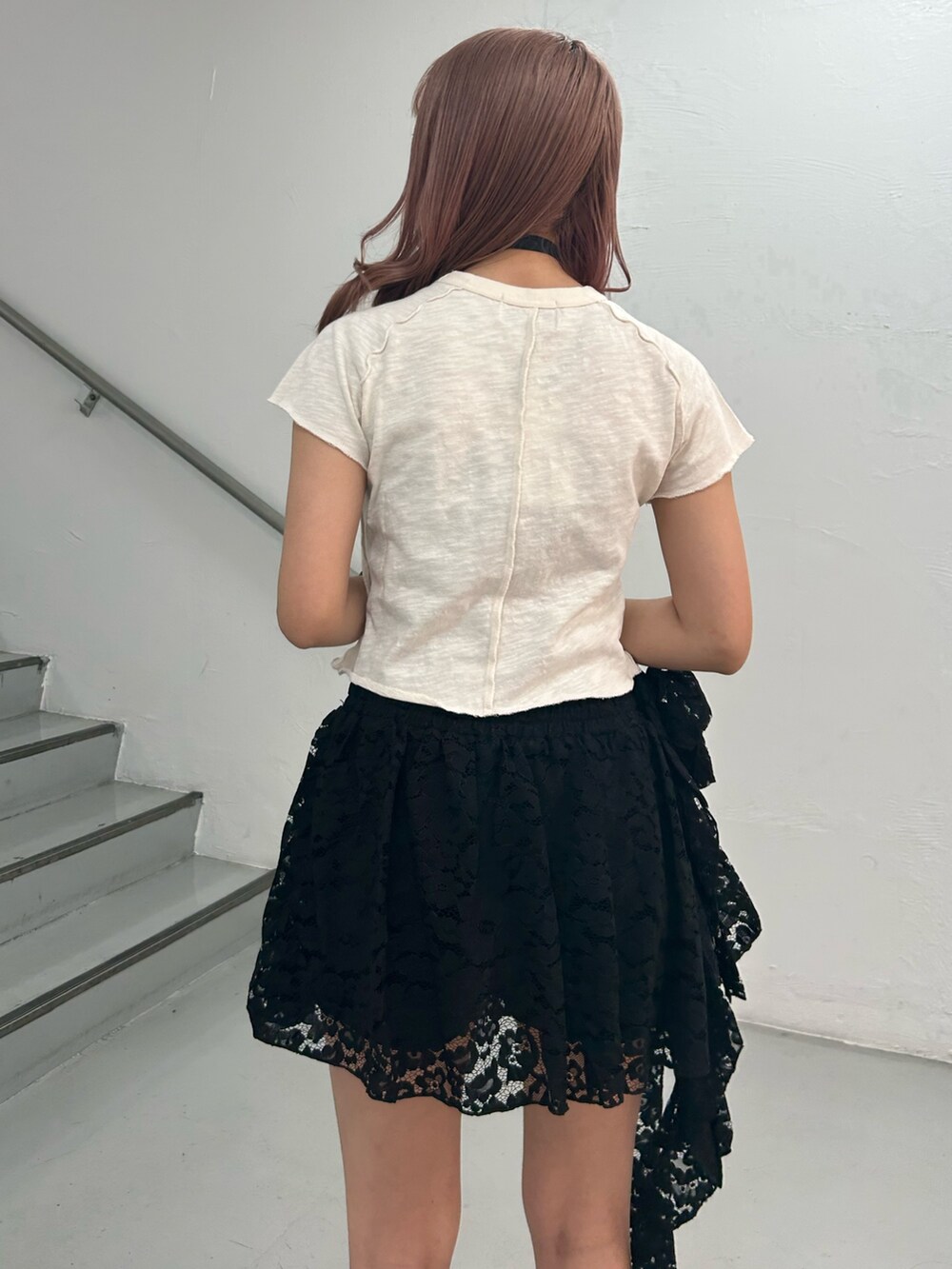 ホワイト系のTシャツ/カットソー、ブラック系のスカート、ブラック系のチョーカーを着用したレディースの春コーディネートの6枚目の写真