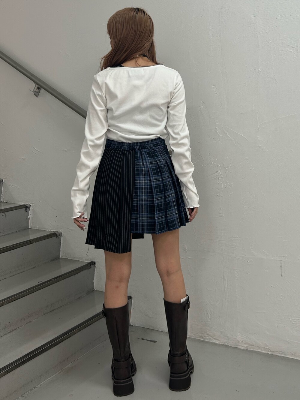 ホワイト系のTシャツ/カットソー、ブルー系のスカート、ブラウン系のブーツを着用したレディースの秋コーディネートの2枚目の写真