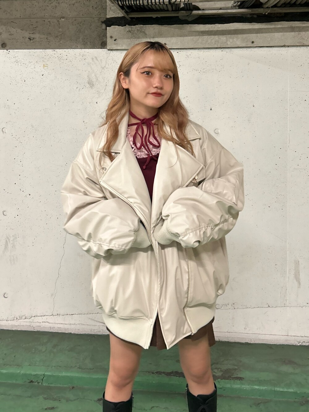 ホワイト系のブルゾン、レッド系のTシャツ/カットソー、ブラウン系のスカートを着用したレディースの秋コーディネートの4枚目の写真