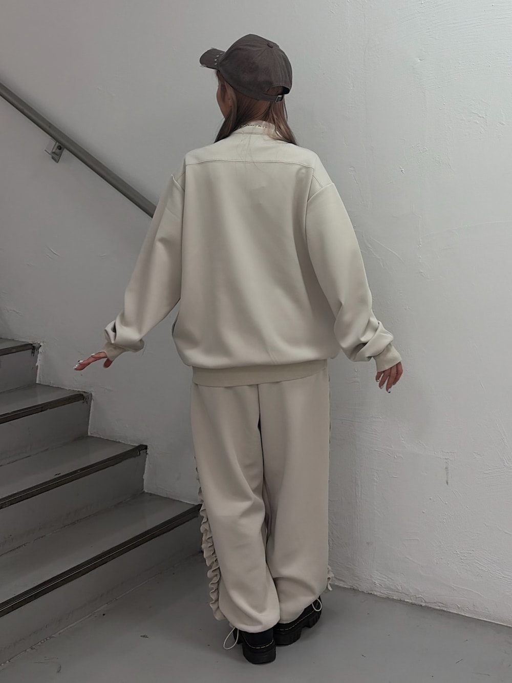 ホワイト系のジャージ、ホワイト系のその他パンツ、ブラウン系のキャップを着用したレディースの冬コーディネートの3枚目の写真