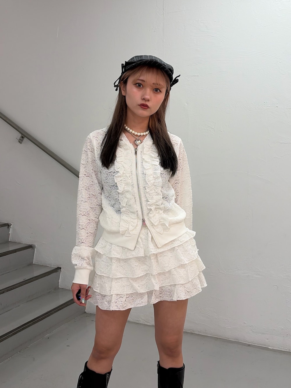 ホワイト系のパーカー、ホワイト系のスカート、グレー系のハンチング/ベレー帽を着用したレディースの春コーディネートの5枚目の写真