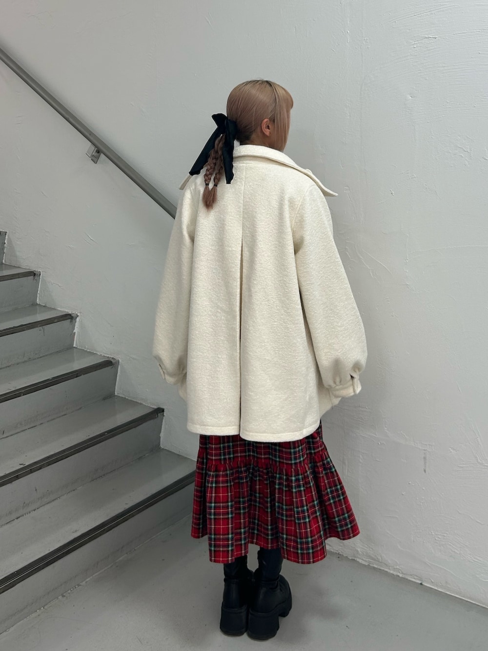 レッド系のワンピース、ホワイト系のその他アウター、ブラック系のバレッタ/ヘアクリップを着用したレディースの冬コーディネートの3枚目の写真