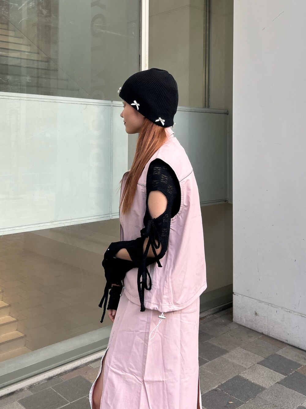 ブラック系のTシャツ/カットソー、ピンク系のベスト、ピンク系のスカートを着用したレディースの春コーディネートの5枚目の写真