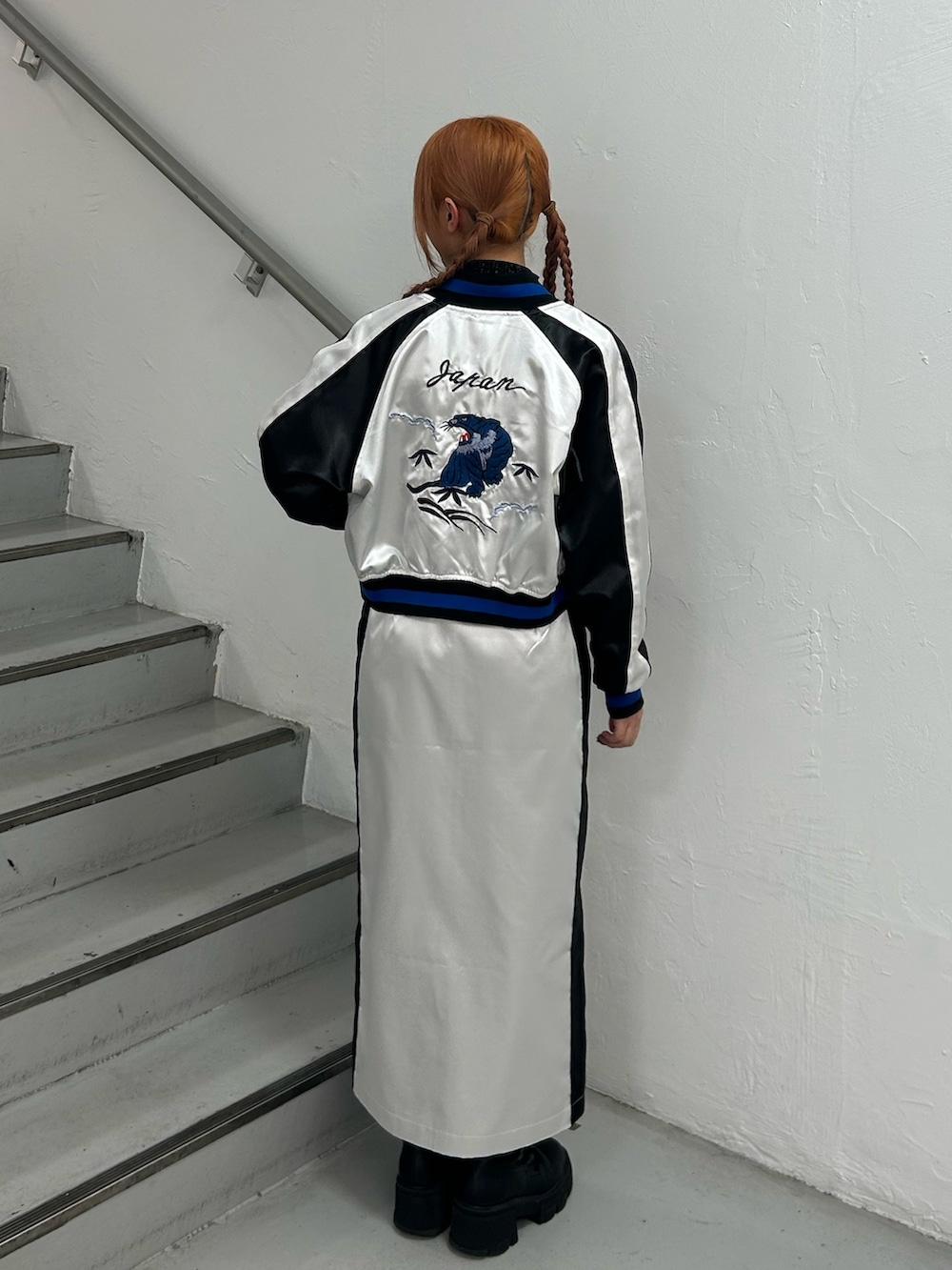 ホワイト系のスカジャン、ブラック系のニット/セーター、ホワイト系のスカートを着用したレディースの春コーディネートの3枚目の写真