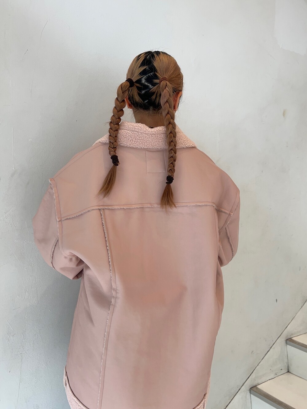 ピンク系のムートンコート、ホワイト系のスウェット、ブラック系のブーツを着用したレディースの秋コーディネートの6枚目の写真