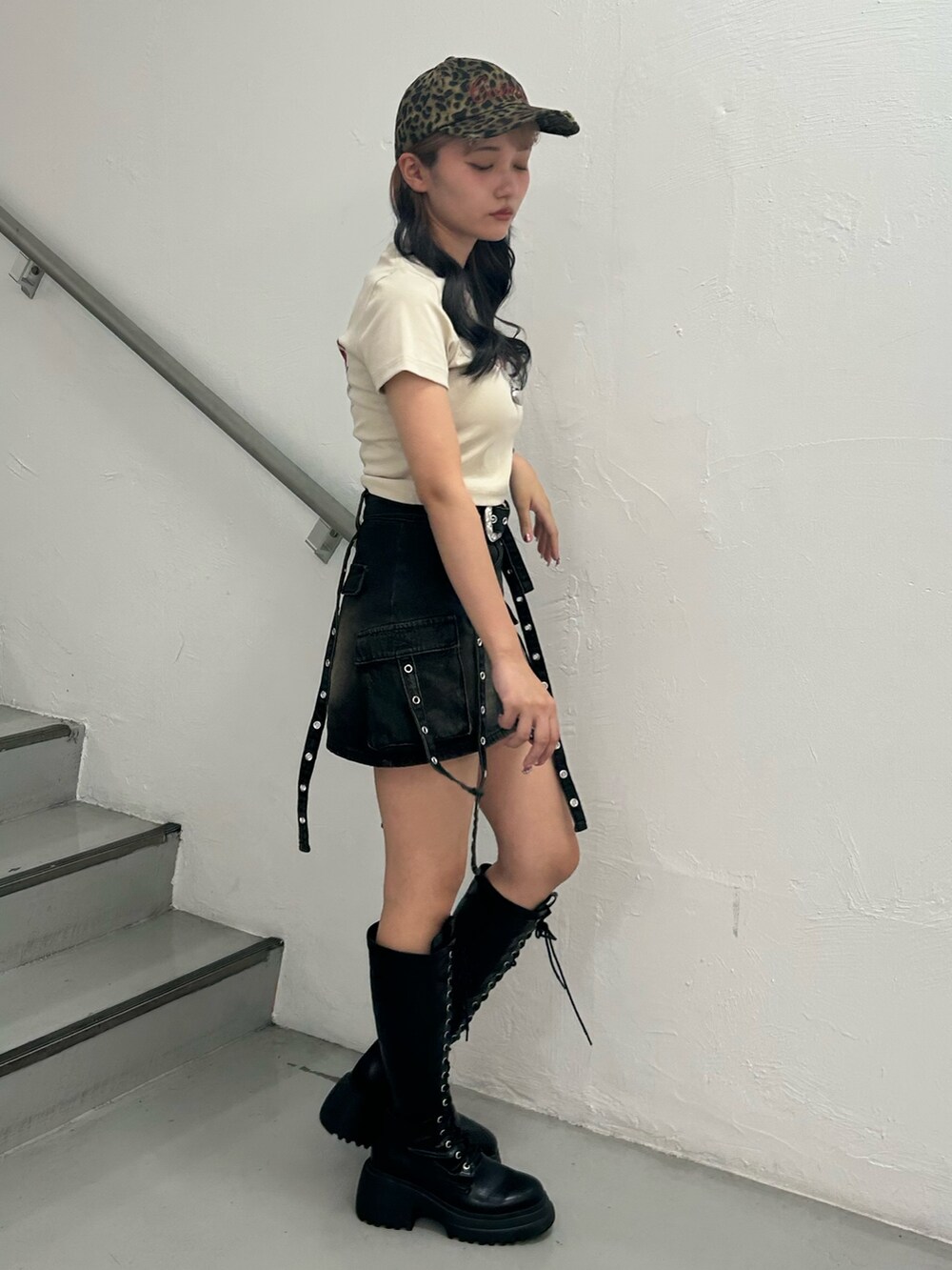 ホワイト系のTシャツ/カットソー、ブラック系のスカート、ブラック系のブーツを着用したレディースの夏コーディネートの2枚目の写真