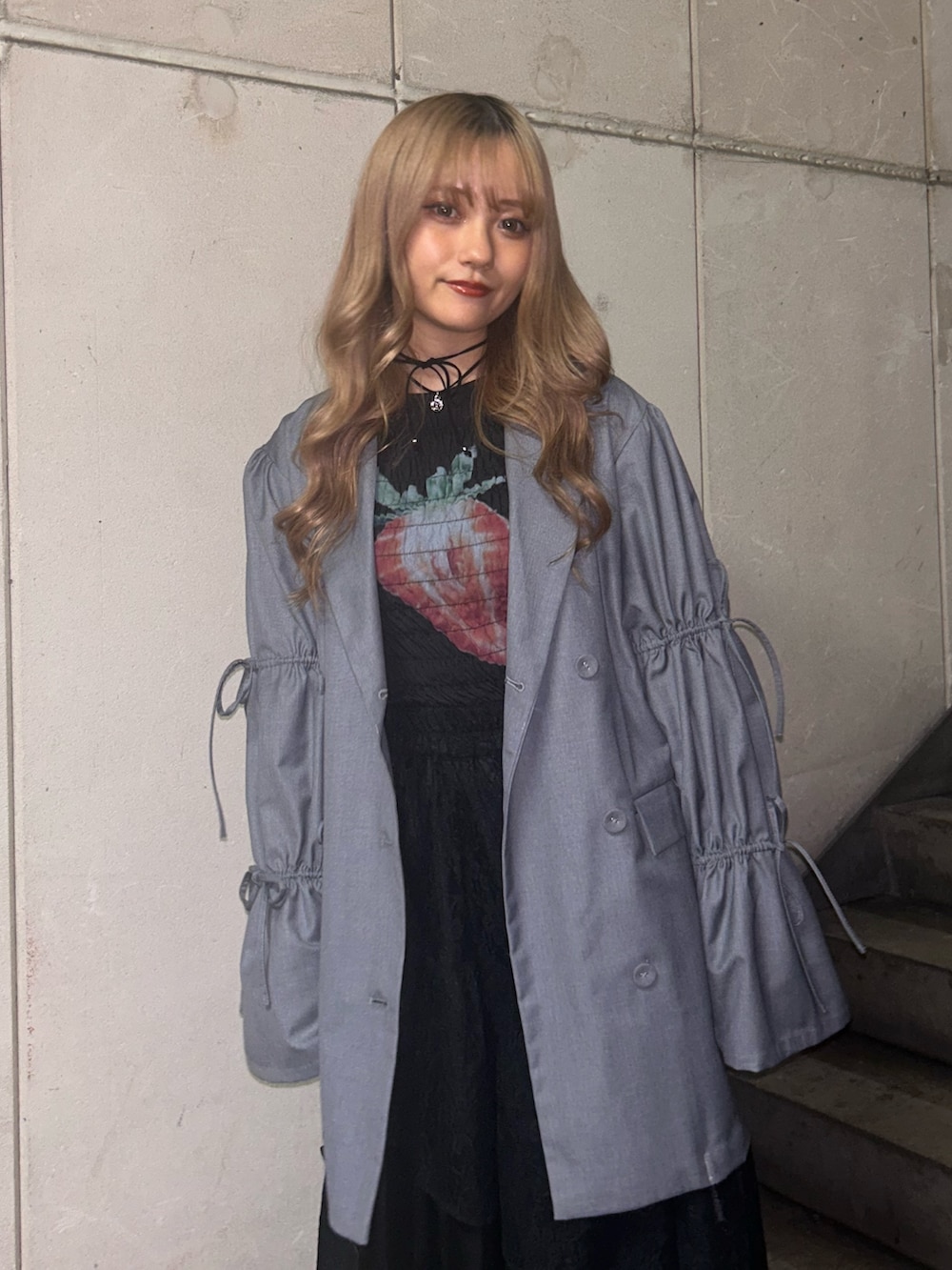 グレー系のテーラードジャケット、ブラック系のTシャツ/カットソー、ブラック系のスカートを着用したレディースの冬コーディネートの4枚目の写真