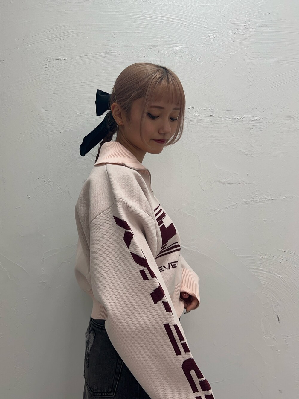 ピンク系のニット/セーター、ブラック系のデニムスカート、ピンク系のネックレスを着用したレディースの冬コーディネートの5枚目の写真