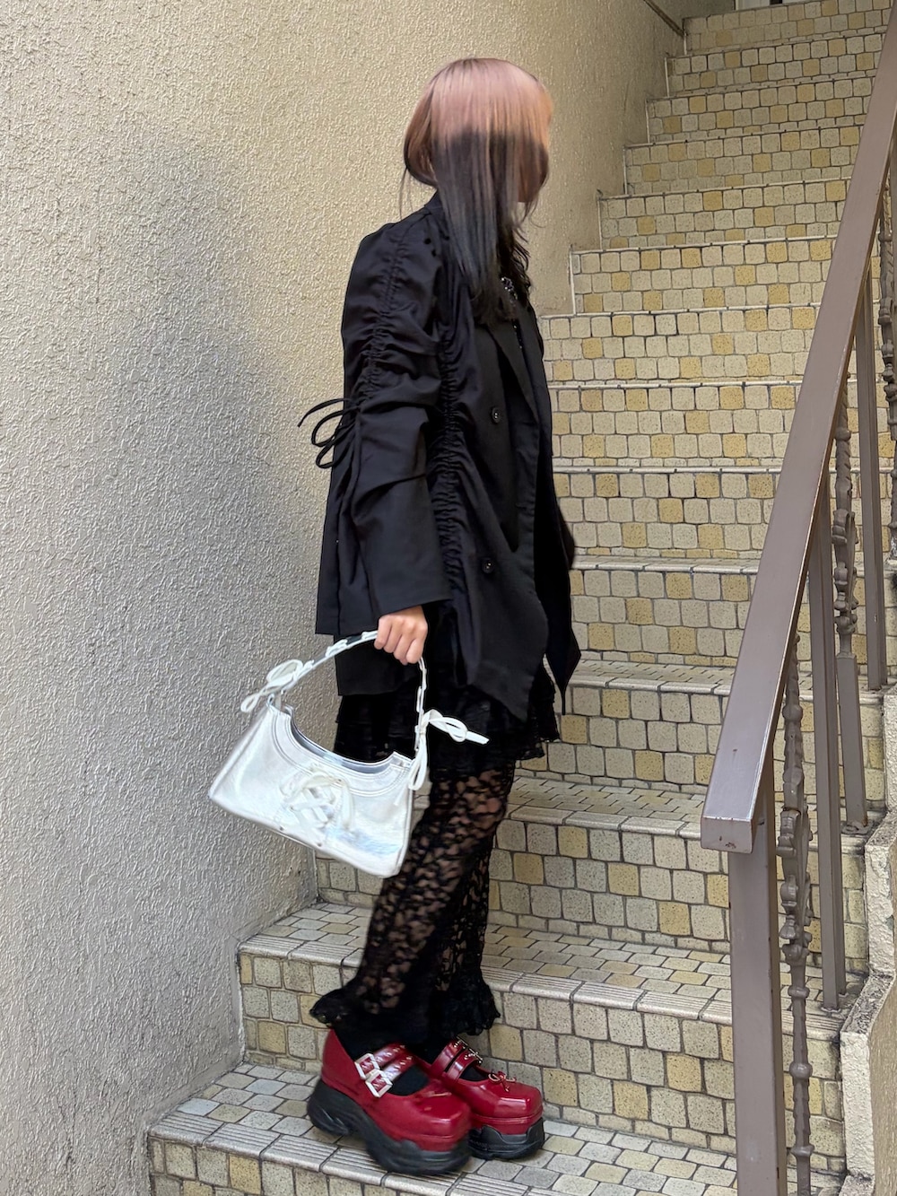 ブラック系のテーラードジャケット、ブラック系のその他パンツ、シルバー系のハンドバッグを着用したレディースの冬コーディネートの2枚目の写真